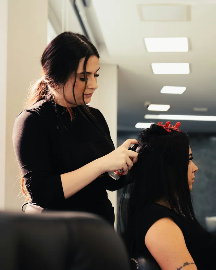 A stylist applying color and styling a client's hair