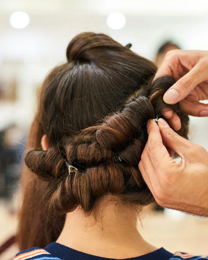 Hands finishing an elegant braided updo